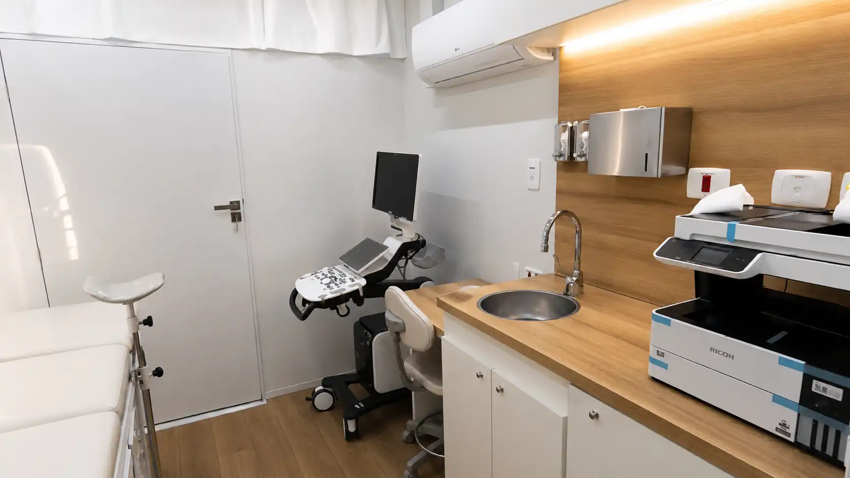 Consultório equipado com ultrassom e mobiliário clínico